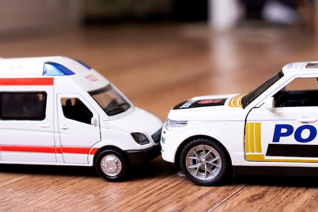 Collision of Toy Ambulance Cars and Police on wooden floor