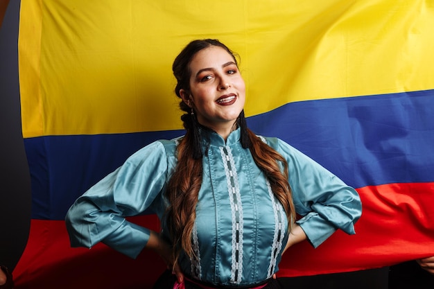 Colombiaanse dame lacht en danst tegen de nationale vlag van Colombia