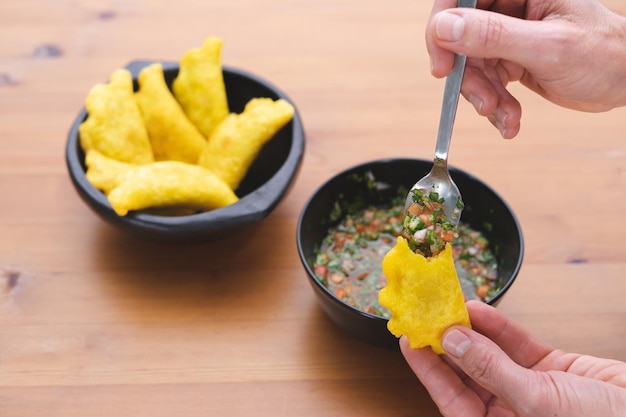 Colombiaanse empanadas. Hand vullen van een empanada met hete paprika. Ruimte kopiëren. Colombiaanse keuken.