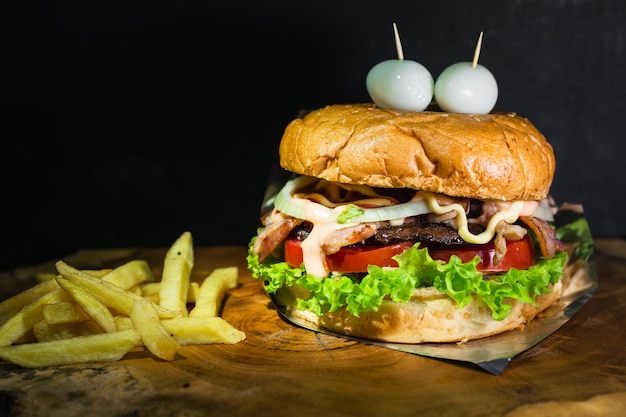 Colombian hamburger with potatoes served on a wooden tray in the shape of a tree trunk