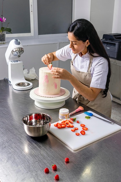 Photo colombian pastry chef chef begins to decorate the cake