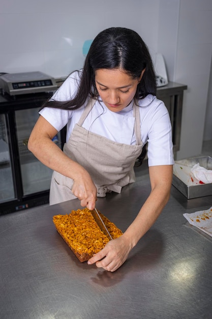 Colombian pastry chef cutting a brownie into small pieces Professional cooking