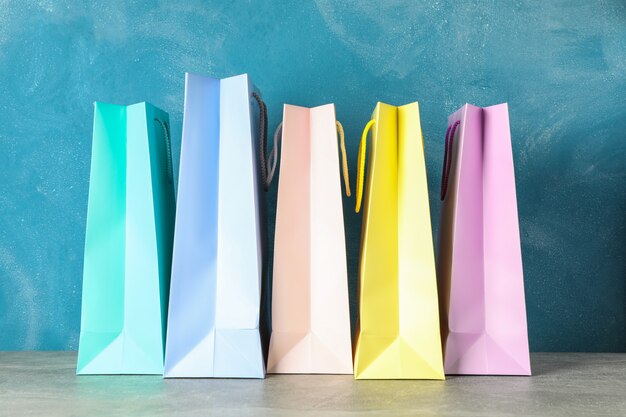 Color bags on grey table against blue