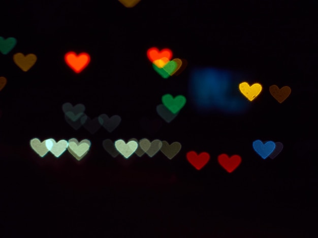 Color bokeh on a dark with hearts.