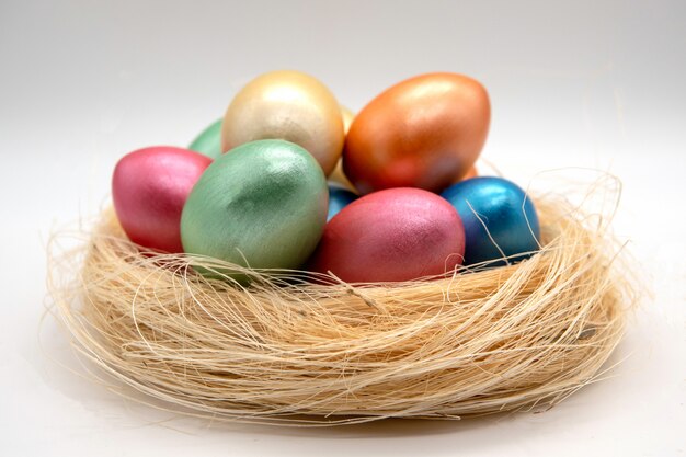 Color easter eggs in basket isolated on white