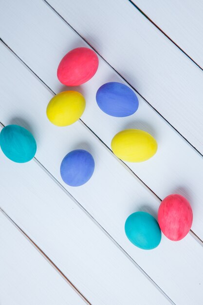 Color easter eggs on white wooden table