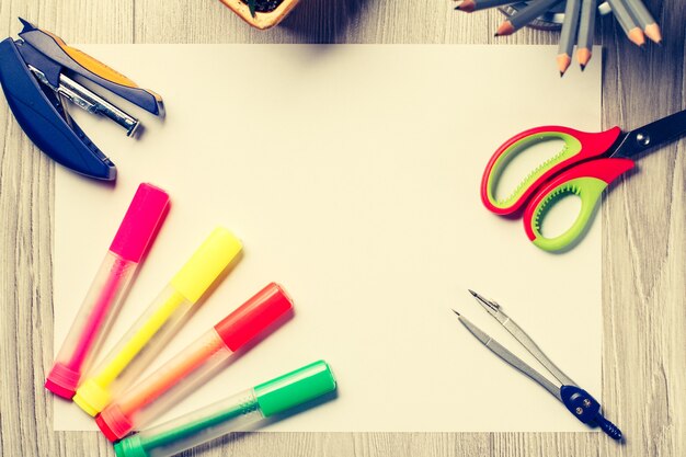 Color felt pens, stapler, compass, scissors and pencils on grey wooden boards with white copy space. Top view. Back to school concept. School supplies.