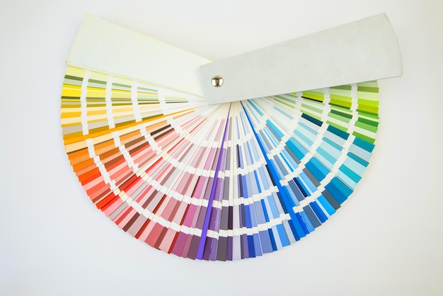 Color guide close up Assortment of colors for design Colors palette fan on white concrete wall background Graphic designer chooses colors from the color palette guide Coloured swatches catalogue