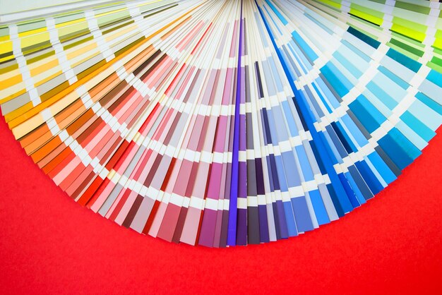 Primo piano della guida dei colori assortimento di fiori per il design ventaglio della tavolozza dei colori su sfondo rosso un grafico seleziona i colori da una guida della tavolozza dei colori catalogo dei campioni di colore