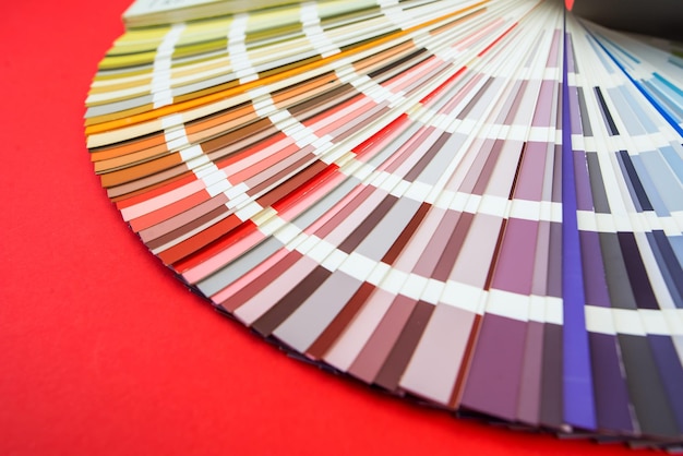 Foto primo piano della guida dei colori assortimento di fiori per il design ventaglio della tavolozza dei colori su sfondo rosso un grafico seleziona i colori da una guida della tavolozza dei colori catalogo dei campioni di colore