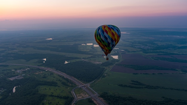 Mongolfiera a colori nella nuvola del cielo e sullo sfondo dell'alba al mattino