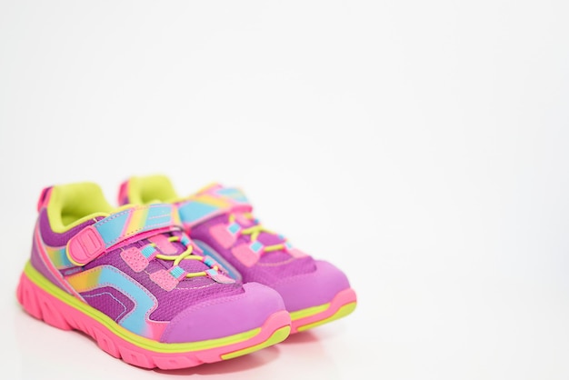 Color kid  sneakers shoes with shoelace on floor side view soft focus copy space