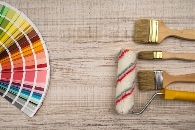 Color palette guide and paint brush roller  on wood board