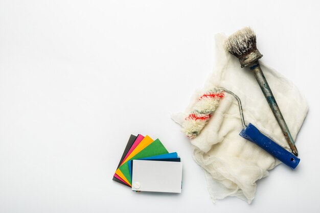 Color palette with shades of paint, paint brushes and rollers on a white