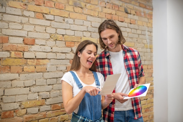 Color palette. Young couple looking at color palette and discussing the wall color