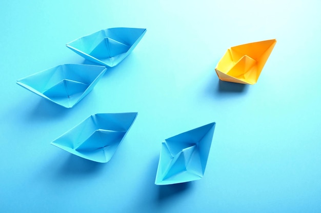 Color paper boats on blue background