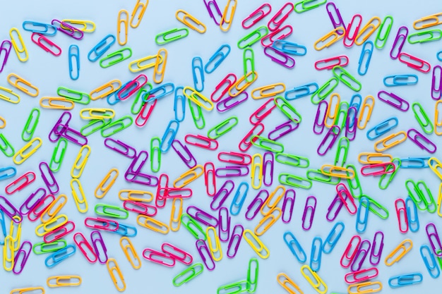 Color paper clips on blue background