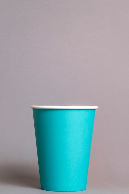 Color paper cup on grey background. Space for text