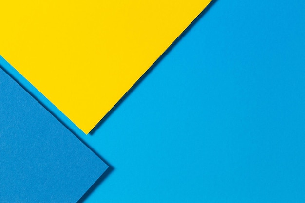 Color papers geometry flat lay composition background with yellow and blue tones