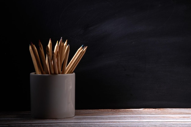 Photo color pencil in cup on a blackboard