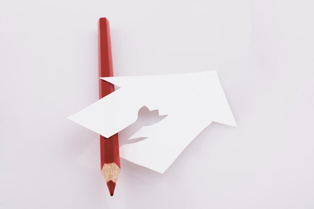 Фото Цветной карандаш возле бумажного домика