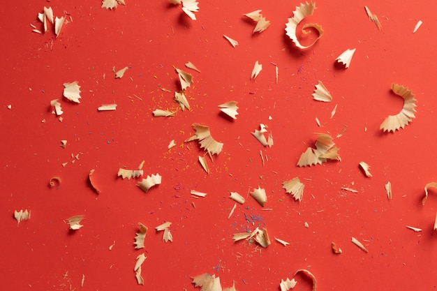 Color pencil shavings and pencils on a red background