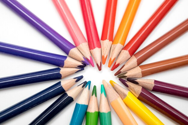 Color pencils in arrange in wheel colors on white background