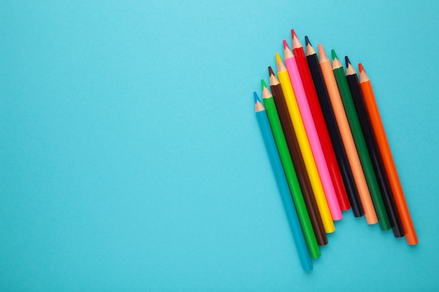 Color pencils on blue background Close up