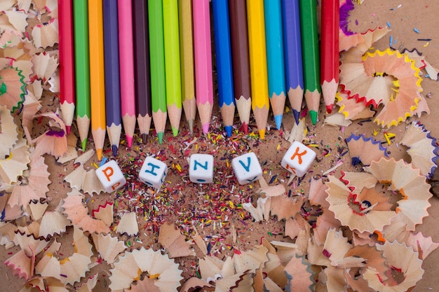 Цветные карандаши и кубики с буквами на карандашной стружке