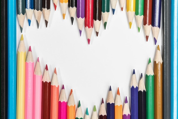 Color pencils lined on white paper in the shape of a heart