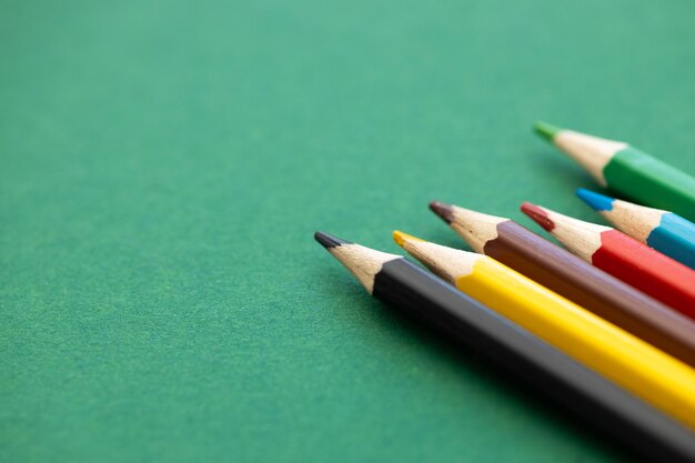 Color pencils with different color over green background