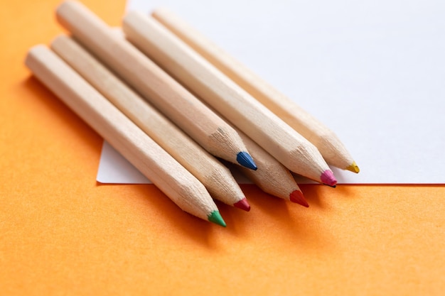 Color pencils with paper on orange