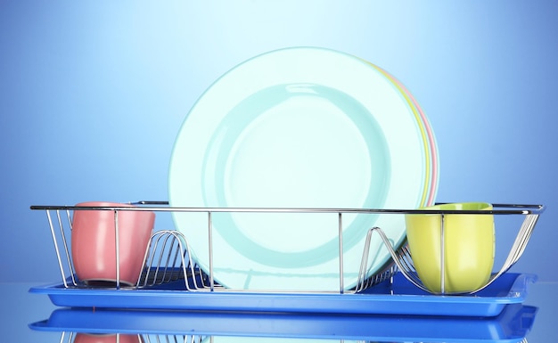 Фото Цветные тарелки в стойке на синем фоне