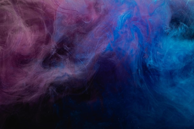 Color smoke background. Fume texture. Paint in water blend. Mystic effect. Soft pigment steam cloud design. Blue pink glitter mist floating in darkness.