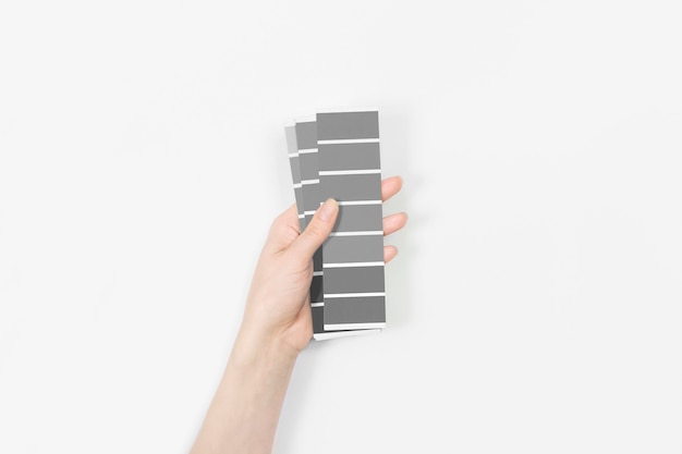 Photo color swatches with color of the year 2021 in the hand - ultimate grey.