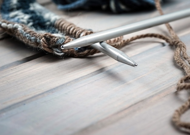 写真 白い木製の背景にニットスカーフ編み針を編むためのカラースレッド