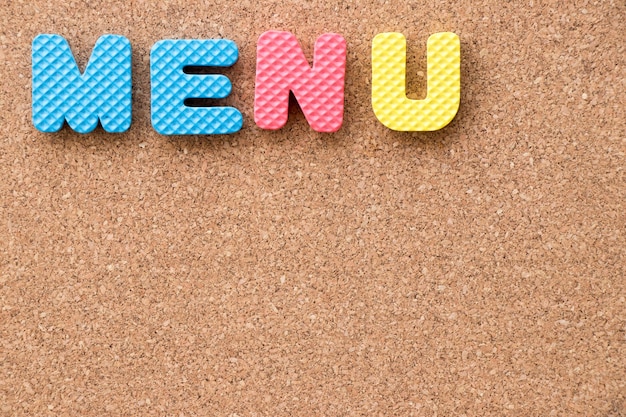 Color toy foam alphabet in word menu on cork board background