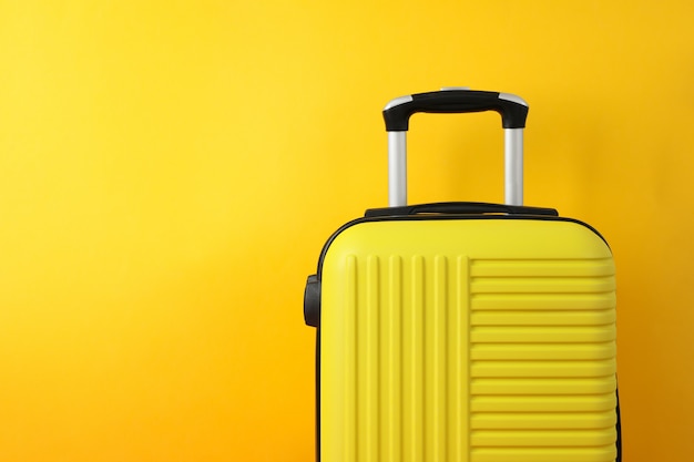 Color travel bag on yellow, space for text