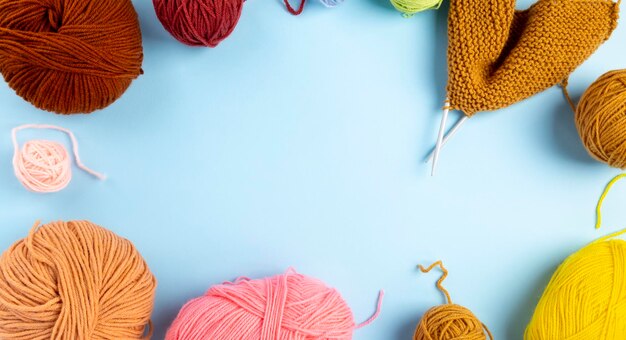 Color yarn for knitting, blue background. Knitting project in progress. Top view. Copy space