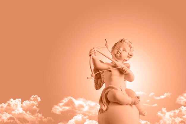 Photo color of the year 2024 peachy fuzz figurine cupid with a bow and arrow background valentine's day