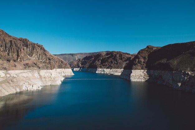 Colorado river amidst mountains against blue sky