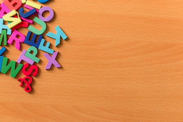 Colored alphabet letters on a wooden background Copy space