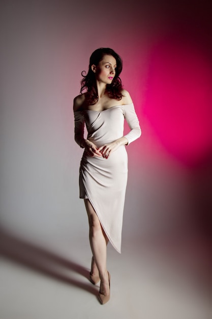 colored background, neon lights, studio shot. fashion portrait of a young elegant brunette woman.