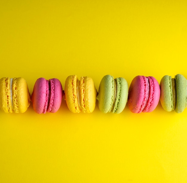 Colored baked cakes of almond flour with cream on yellow