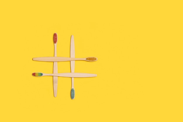 Colored bamboo wood thoothbrush on a yellow background