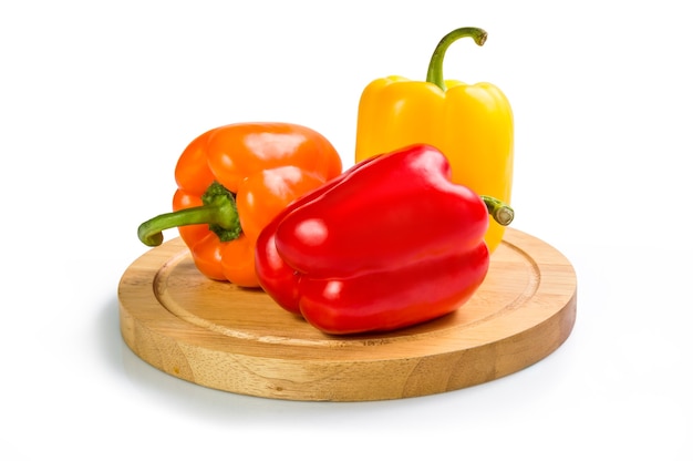 Colored bell peppers on cutting board isolated