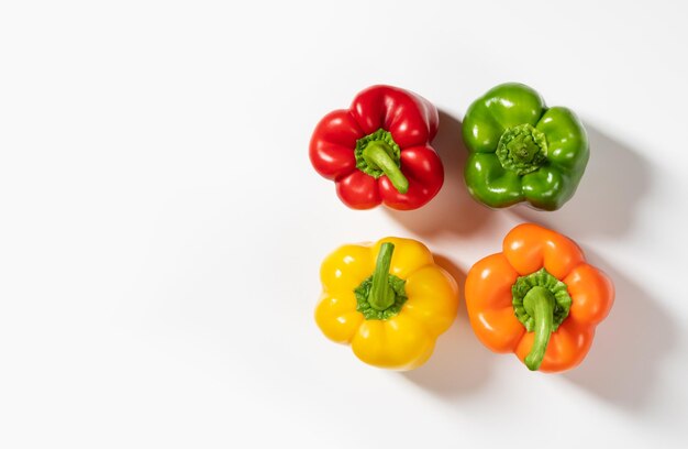 Colored bell peppers on white background