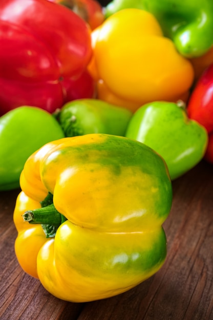 Colored bell peppers on wooden background