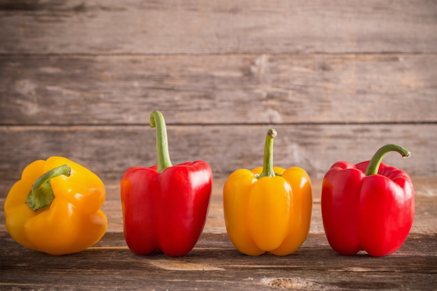 Colored bell peppers on wooden table