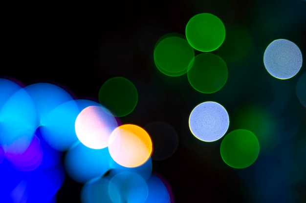 Цветное размытое боке. абстрактный фон из включенных праздничных гирлянд. красочные размытие лампочки